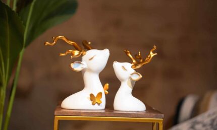Snowy serenity - White and gold deer figures in repose